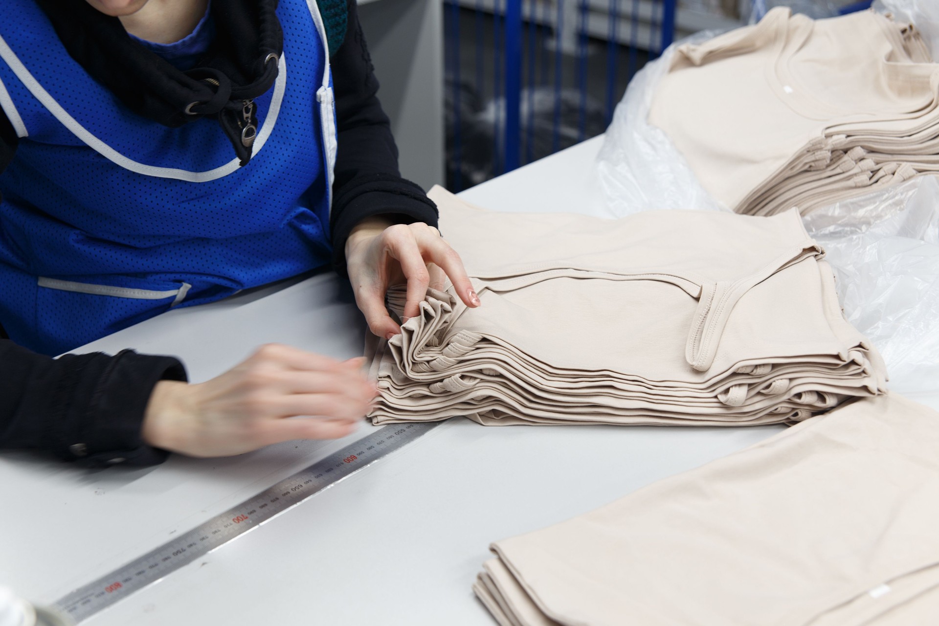 Close up hands of worker at clothing company labelling their product.